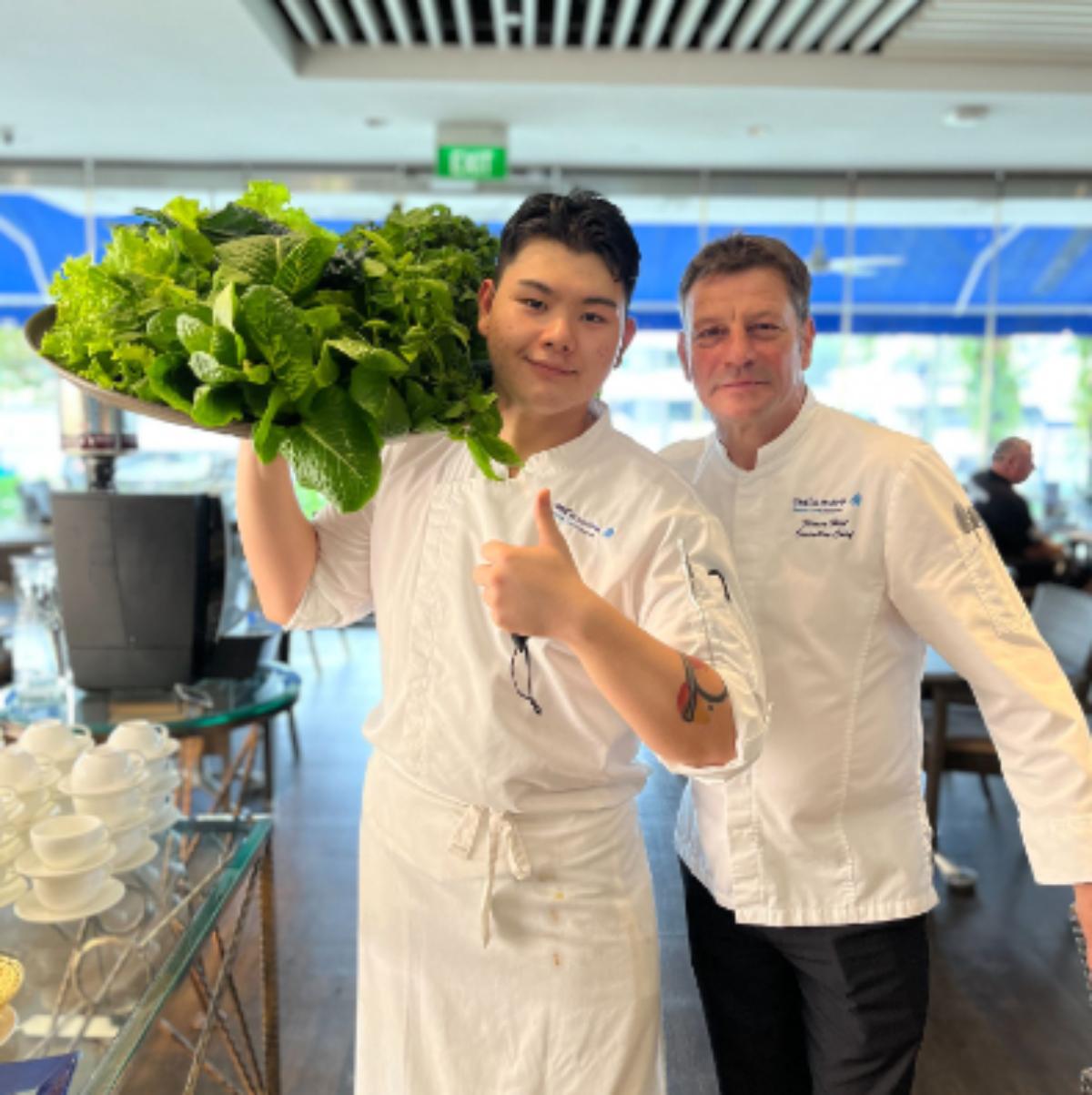 Two chefs holding produce they grew in a vertical garden